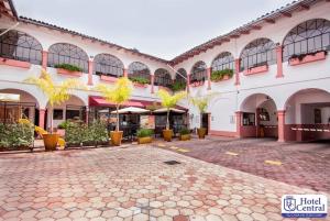 a large building with a courtyard with potted plants at Hotel Central Teziutlan in Teziutlán
