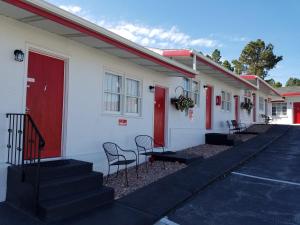 uma fila de casas com portas vermelhas e cadeiras em Rocket Motel em Custer