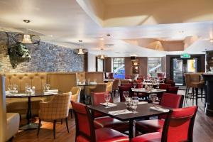 a restaurant with tables and chairs and a brick wall at Glasgow Grosvenor Hotel in Glasgow