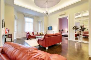 a living room with leather furniture and a chandelier at Sweet Dreams at Chain Bridge in Budapest