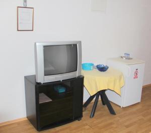 een televisie op een stand met een kleine tafel bij Guesthouse Donko 1 & 2 in Senj
