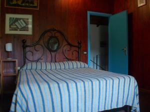 um quarto com uma cama com um cobertor listrado em casa al colle em Lucca