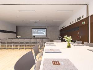 une salle de conférence avec des tables, des chaises et un écran dans l'établissement Valavier Aktivresort, à Brand