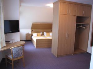 ein Hotelzimmer mit einem Bett, einem Schrank und einem Schreibtisch in der Unterkunft Pension Haus Wernemann in Bad Rothenfelde
