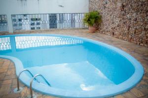 una gran piscina con bañera azul en un edificio en Flat Oeste La Residence, en Goiânia