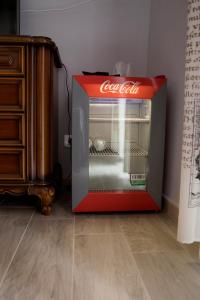 アルバにあるLe camere di Gioのドレッサーの横にあるオープンコカコーラ冷蔵庫