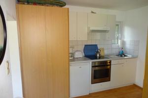 a kitchen with white cabinets and a stove top oven at Ferienhaus Julia in Stechlin