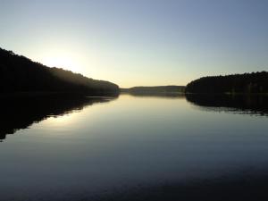 a view of a lake with the sun setting at Ferienhaus Julia in Stechlin