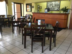 a restaurant with wooden tables and chairs and a counter at Super 8 by Wyndham Walterboro in Walterboro