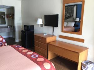 a hotel room with a bed and a mirror at Super 8 by Wyndham Walterboro in Walterboro