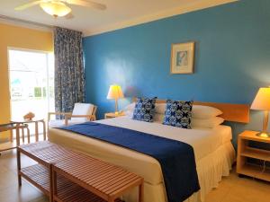 ein Schlafzimmer mit einem großen Bett mit blauen Wänden in der Unterkunft Flamingo Bay Hotel & Marina in Freeport