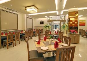 a restaurant with wooden tables and chairs and a chalkboard at Hotel Sai Jashan in Shirdi