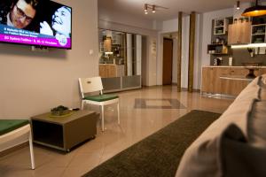 a living room filled with furniture and a tv at Dynasta Central Suites in Athens