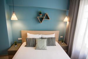 a bedroom with a bed and a lamp on the wall at Dynasta Central Suites in Athens