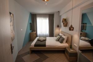 una piccola camera con letto e specchio di Dynasta Central Suites ad Atene