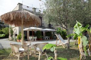 a group of chairs and umbrellas in front of a building at Residenza Casale San Francesco free parking in Tropea