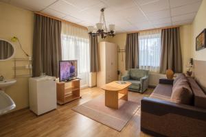 - un salon avec un canapé, une télévision et une table dans l'établissement Endla Hotell, à Viljandi