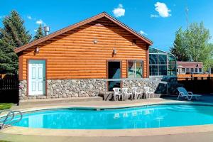 a log cabin with a pool in front of it at Nordic Lodge in Steamboat Springs