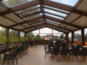 a conservatory with tables and chairs and windows at Neptun in Międzychód