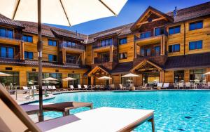 una piscina de hotel con mesas, sillas y sombrillas en Zalanta en South Lake Tahoe