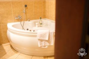 a bathroom with a white tub and a sink at L'ascada in Śrem
