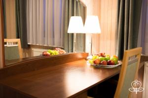 a table with a bowl of fruit and a lamp at L'ascada Hotel in Śrem