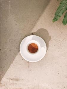 a cup of coffee on a white plate on the ground at Hotel Karel in Arnhem