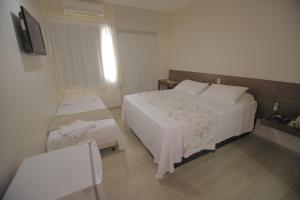 a hotel room with two beds and a television at Hotel Plenotel in Collatina