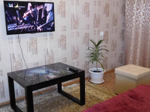 イジェフスクにあるАпартСтандарт Столичныйのリビングルーム(ガラステーブル、テレビ付)