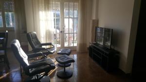een woonkamer met 3 stoelen en een flatscreen-tv bij Departamento del Mar in Mar del Plata
