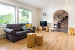 a living room with a couch and two wooden stools at Zöldbarát Vendégház in Nyíregyháza