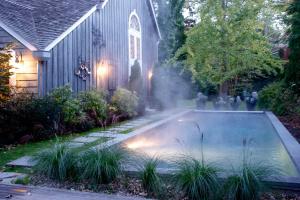 een zwembad in de tuin van een huis met verlichting bij Mill House Inn in East Hampton