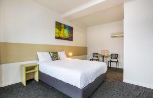 um quarto de hotel com uma cama e uma mesa em Boomerang Hotel em Albury