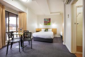 um quarto de hotel com uma cama, uma mesa e cadeiras em Boomerang Hotel em Albury