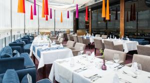 コウォブジェクにある3L Apartments Aquariusの白いテーブルと椅子、カラフルなシャンデリアが備わるレストラン