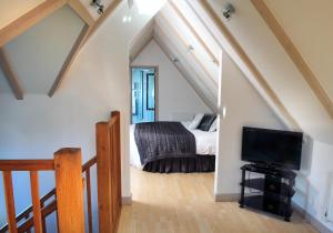 a bedroom with a bed and a tv in a attic at Little Silver Country Hotel in Tenterden