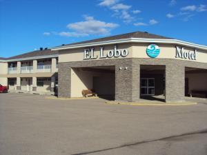 El Lobo Motel في Cold Lake: مبنى مع علامة أيجيل لودو في الأمام