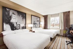 um quarto de hotel com duas camas e uma janela em Super 8 by Wyndham Winnipeg West em Winnipeg