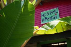 a large green leaf in front of a house with a sign at Hostal Hansi in Bocas Town