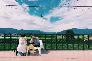 Una novia y un novio sentados en sillas en un patio en Puli Islet Inn en Puli