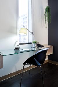 a desk with a lamp and a chair next to a window at ibis Sydney Barangaroo in Sydney