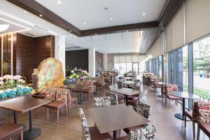 a restaurant with tables and chairs and windows at Hoya Hotel Taitung in Taitung City
