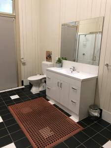 a bathroom with a sink and a toilet and a mirror at Exchange Hotel Toogoolawah in Toogoolawah