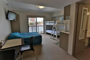 Habitación pequeña con cama, escritorio y mesa. en Strathfield Executive Accommodation, en Sídney