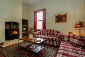 a living room with two couches and a fireplace at Belgravia Mountain Guest House in Katoomba