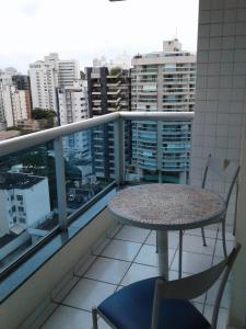einen Balkon mit einem Tisch und Stühlen sowie Stadtblick in der Unterkunft Apart Quartier Latin Hotel in Vitória