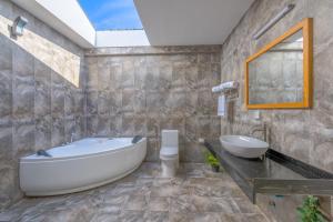 a bathroom with a tub and a sink and a mirror at White Sand Dhigurah in Dhigurah +39 photos