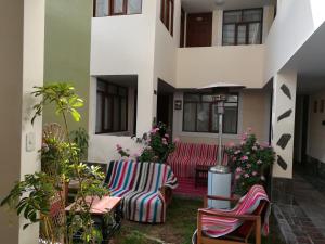 a patio with two chairs and tables and flowers at La Casa de Anita in Chivay