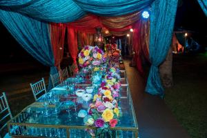 a long table with blue and red drapes and flowers at El Lugar Boutique Hotel in Pereira