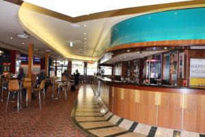 a bar in a cruise ship with people sitting at tables at Guildford Hotel in Guildford